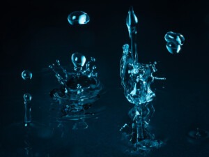 Wassertropfen und Spritzer vor dunklem Hintergrund