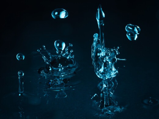 Wassertropfen und Spritzer vor dunklem Hintergrund